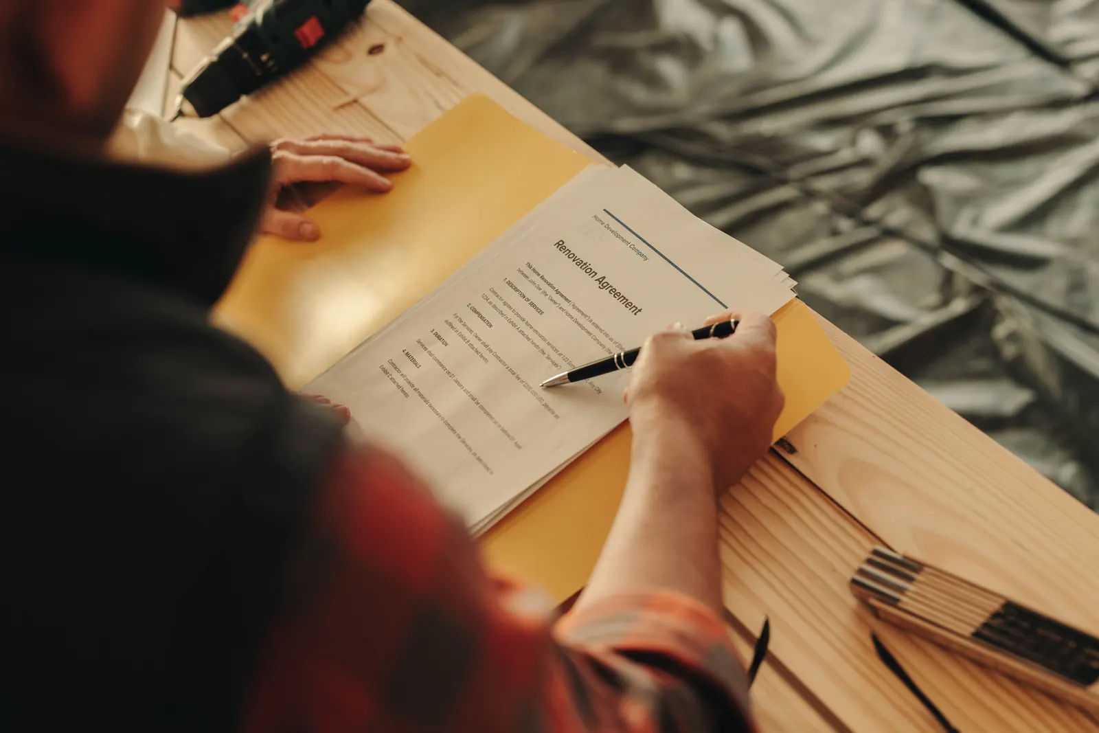 Contractor reviewing and signing a renovation agreement